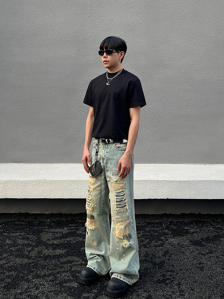 ダメージ加工された泥染めのストレートフレアパンツ