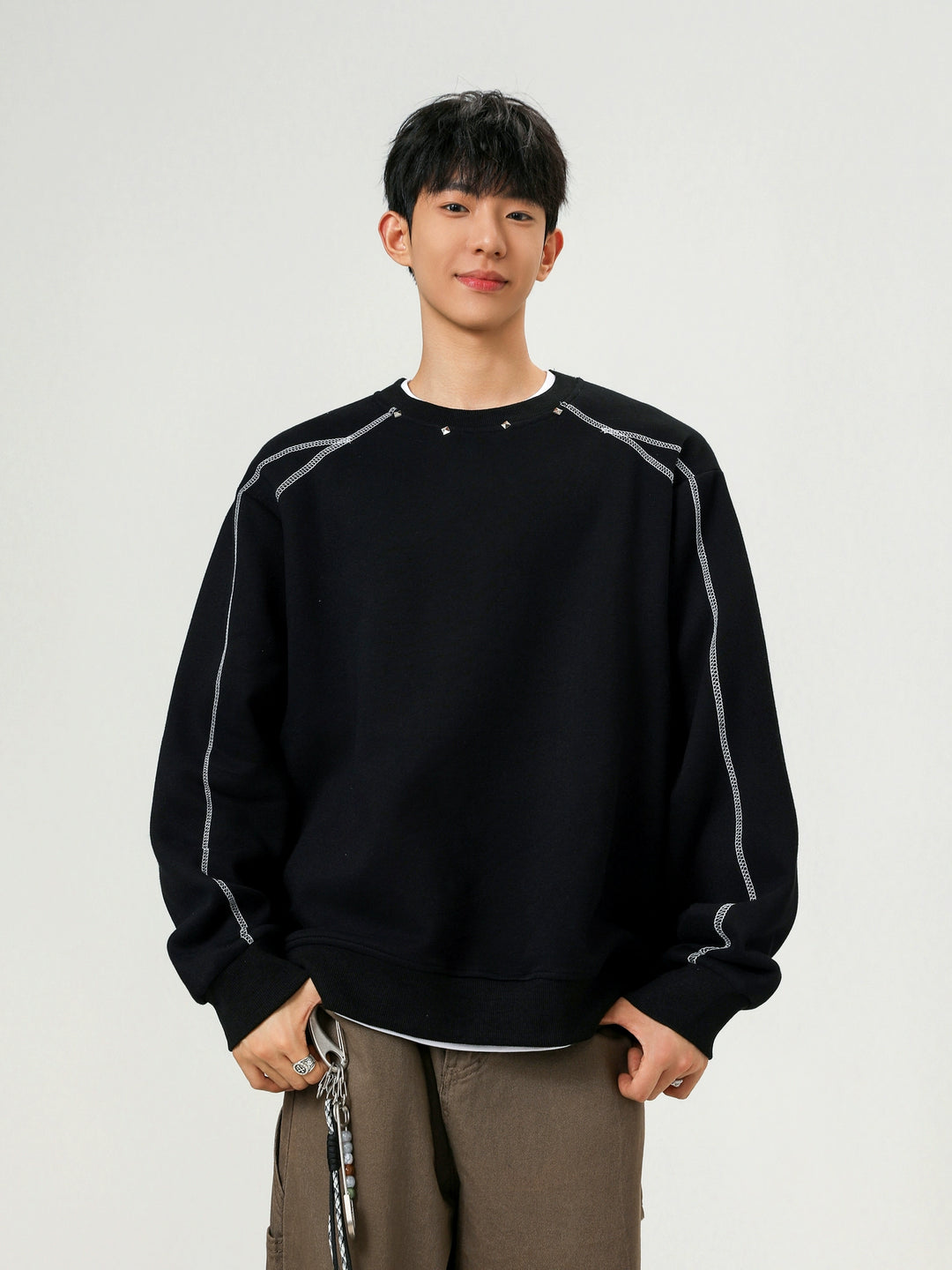 سويت شيرت فضفاض بياقة دائرية مزين بالمسامير 