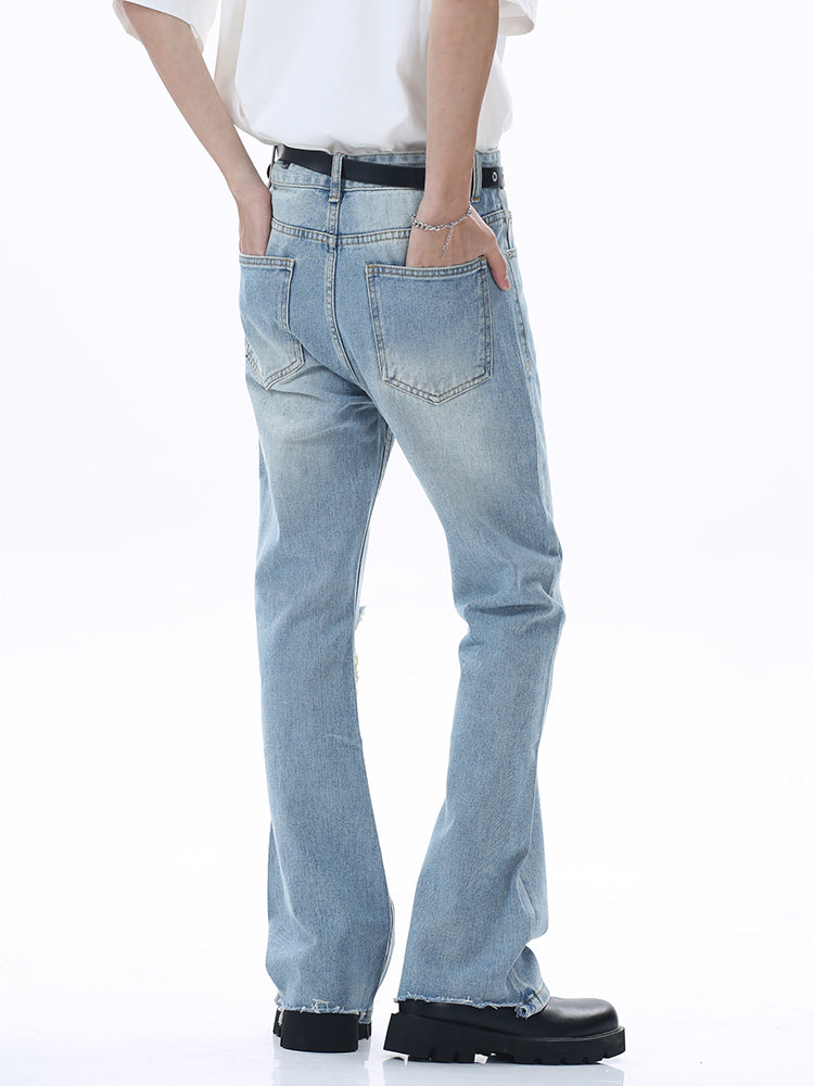 Knie-gerissene gewaschene ausgestellte Jeanshose 